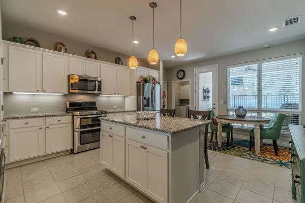 a kitchen with cabinets and chairs