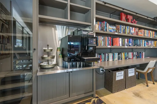 a room with a table chairs and a book shelf