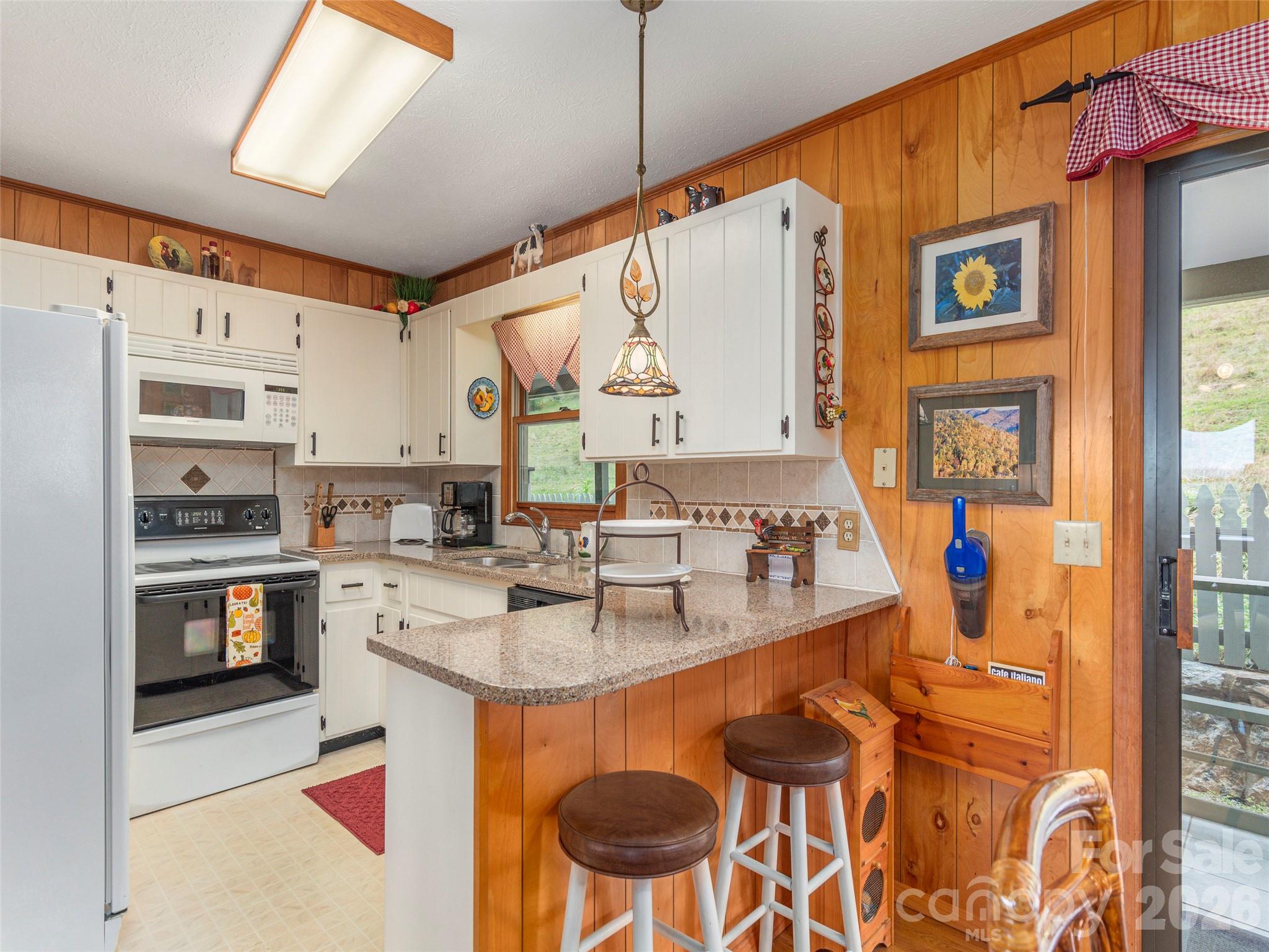 21 Flint Lane Maggie Valley, NC 28751 - Photo 11 of 30 a kitchen with stainless steel appliances granite countertop a sink and a refrigerator