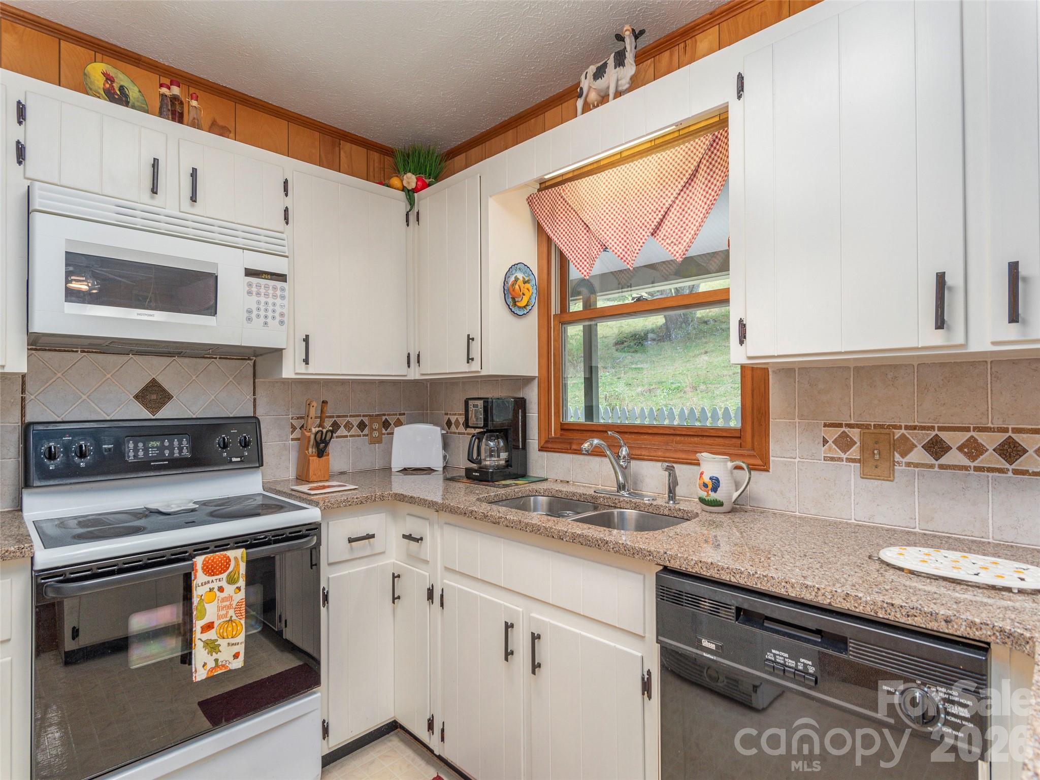 21 Flint Lane Maggie Valley, NC 28751 - Photo 12 of 30 a kitchen with stainless steel appliances granite countertop a stove a sink and a microwave
