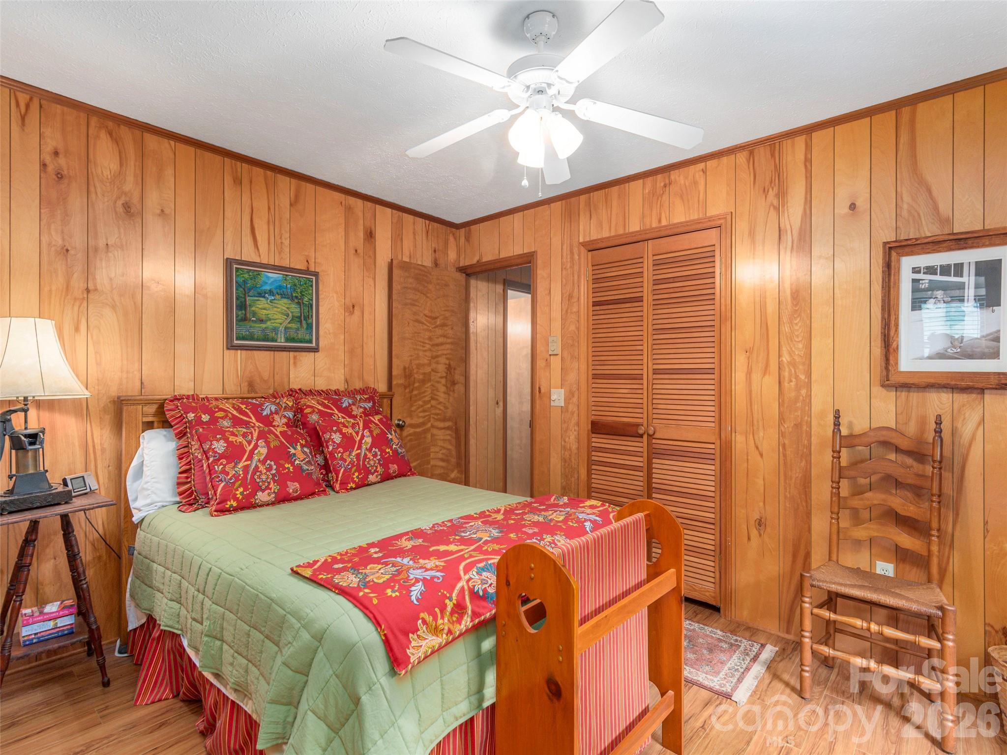 21 Flint Lane Maggie Valley, NC 28751 - Photo 16 of 30 a bedroom with a bed a dresser and a chandelier