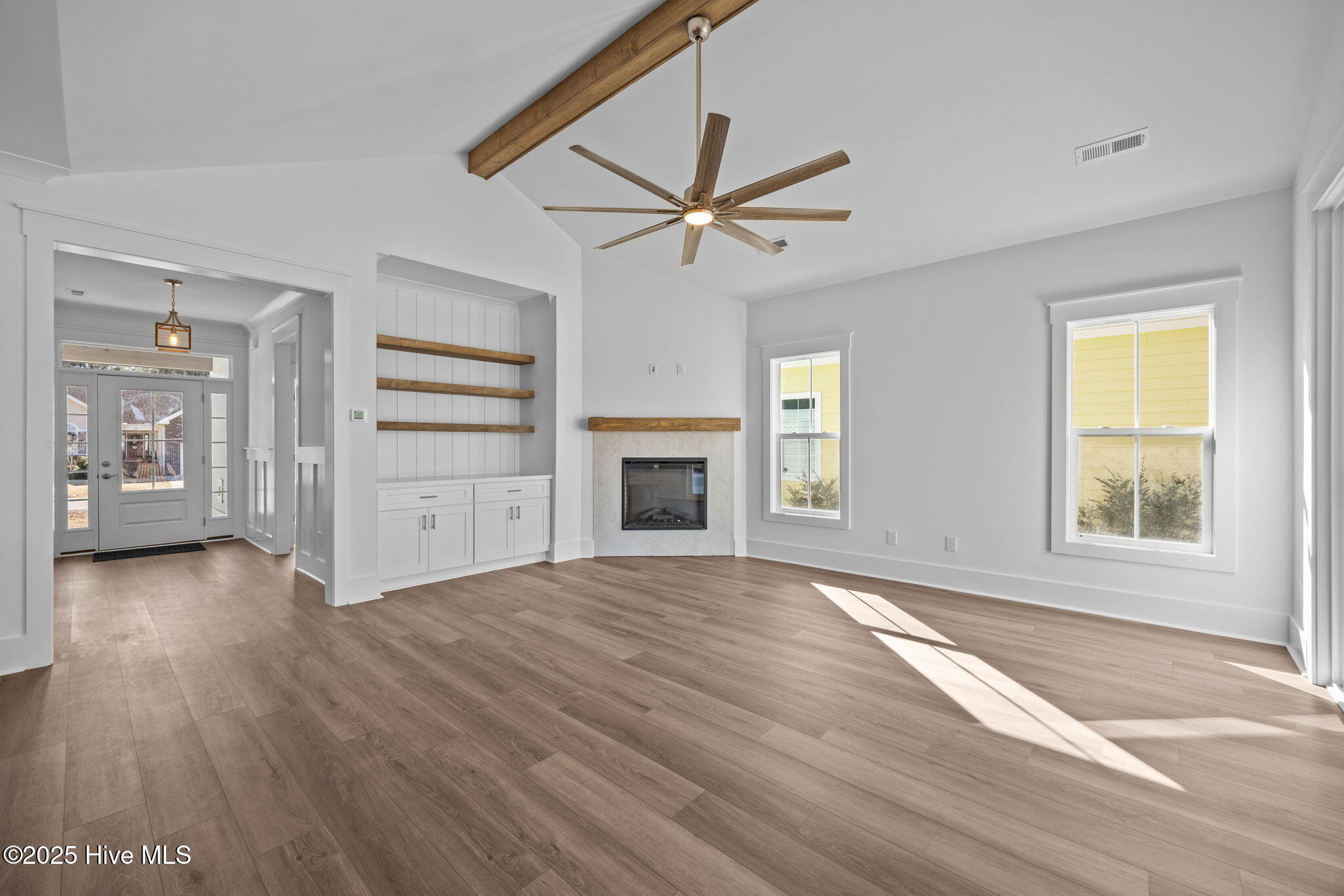 498 Genoe's Point Road Southwest Supply, NC 28462 - Photo 8 of 55 Large Open living Room with corner Herringbone tiled Fireplace with wood mantle and center beam and built ins
