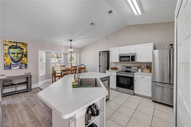 a kitchen with white cabinets and stainless steel appliances