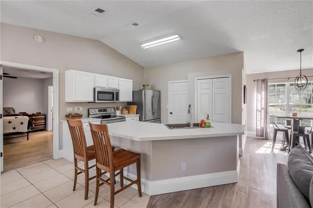a view of kitchen with sink microwave and dining table