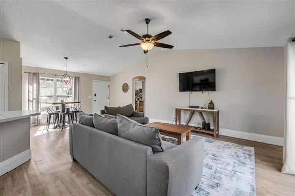 a living room with furniture a ceiling fan and a rug