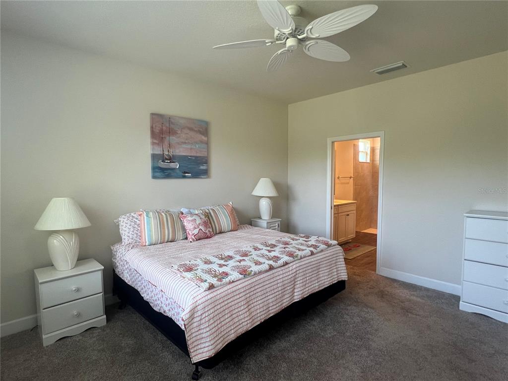 9912 Sheltering Spruce Street Englewood, FL 34223 - Photo 18 of 55 a bedroom with a bed and a chandelier