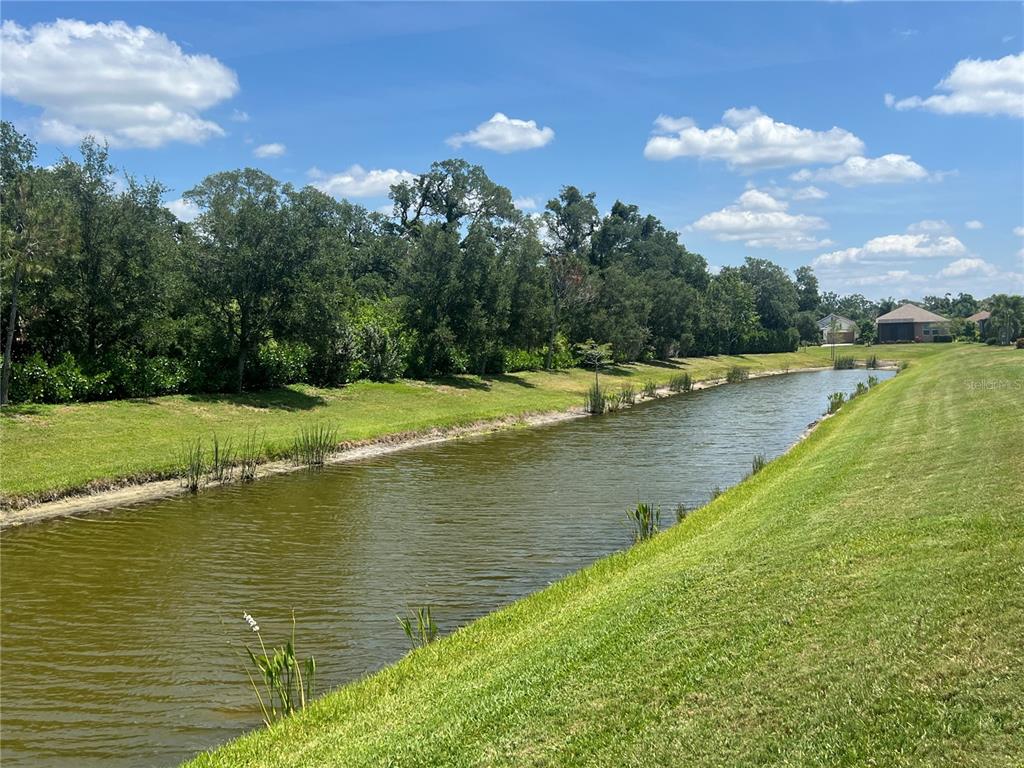 9912 Sheltering Spruce Street Englewood, FL 34223 - Photo 43 of 55 a view of a lake with a yard