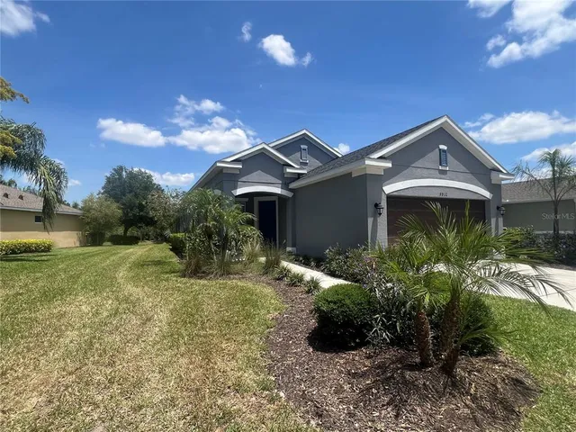 a view of a patio with dining table chairs and a small yard