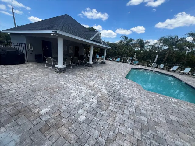 a row of palm trees and swimming pool in the backyard of a house