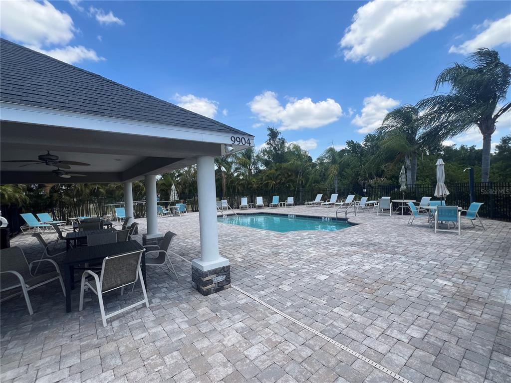 9912 Sheltering Spruce Street Englewood, FL 34223 - Photo 52 of 55 a view of a patio with dining table chairs and a small yard