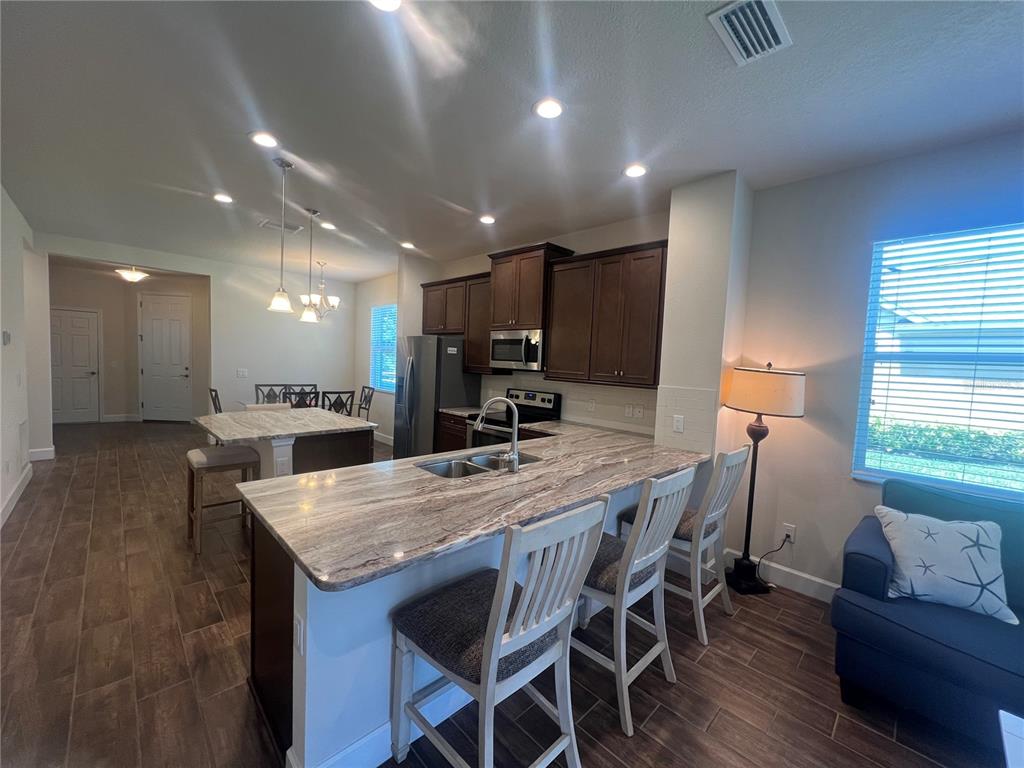 9912 Sheltering Spruce Street Englewood, FL 34223 - Photo 6 of 55 a kitchen with a table and chairs in it