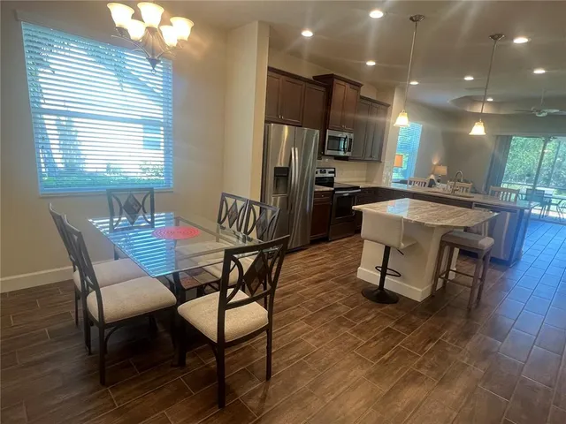 a kitchen with stainless steel appliances a refrigerator and a wooden floor