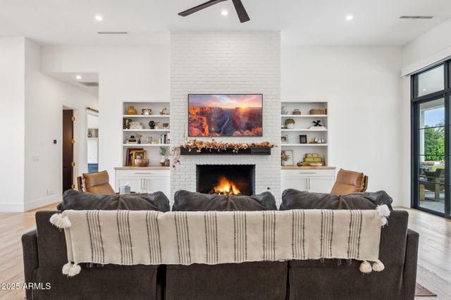 a kitchen with stainless steel appliances kitchen island granite countertop a refrigerator a stove a sink a dining table and chairs with wooden floor