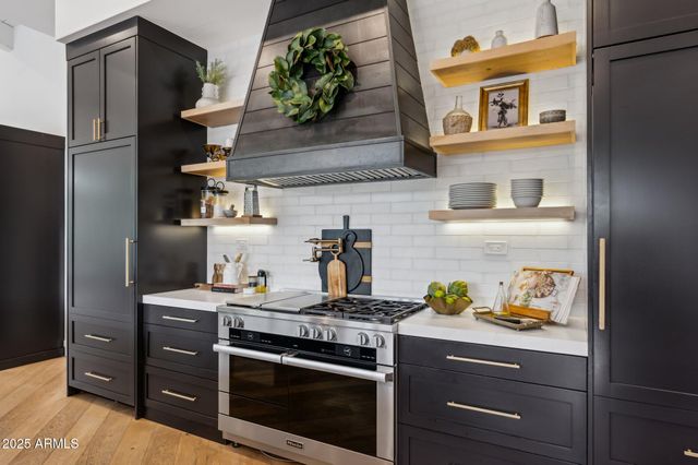 a kitchen with stainless steel appliances granite countertop a sink a stove and a refrigerator