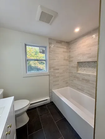 a bathroom with a toilet sink and mirror