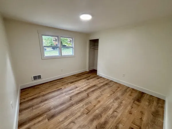 wooden floor in an empty room with a window