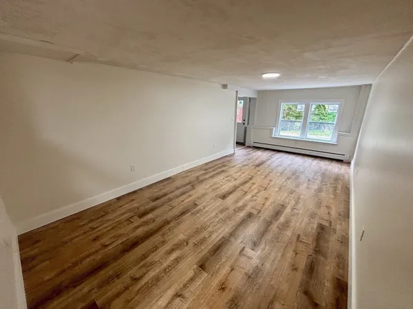 a view of empty room with wooden floor