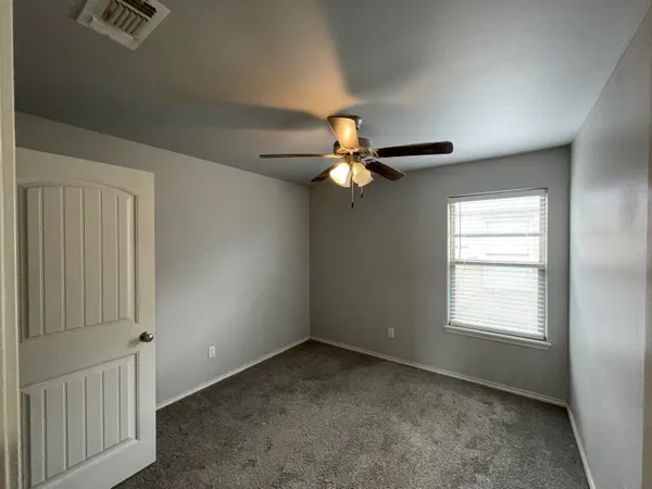 a view of a livingroom with a ceiling fan and window