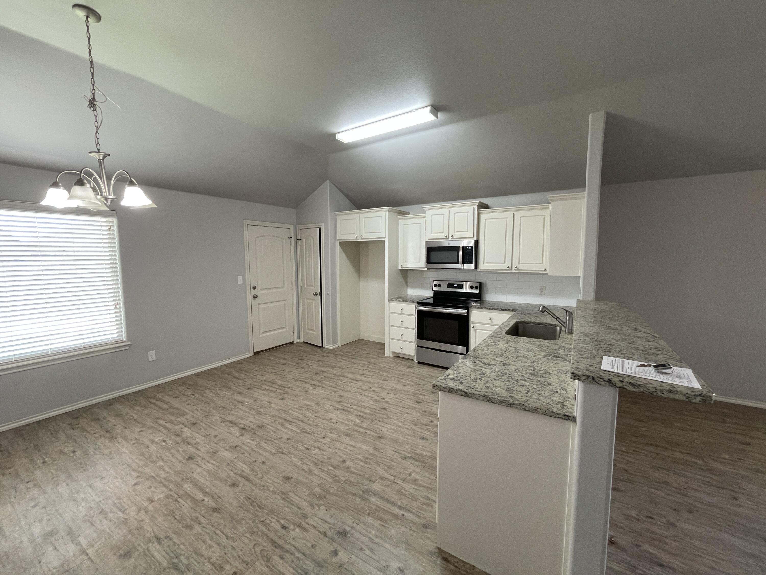 1012 Preston Trail Wolfforth, TX 79382 - Photo 5 of 21 a kitchen with granite countertop a sink cabinets and stainless steel appliances