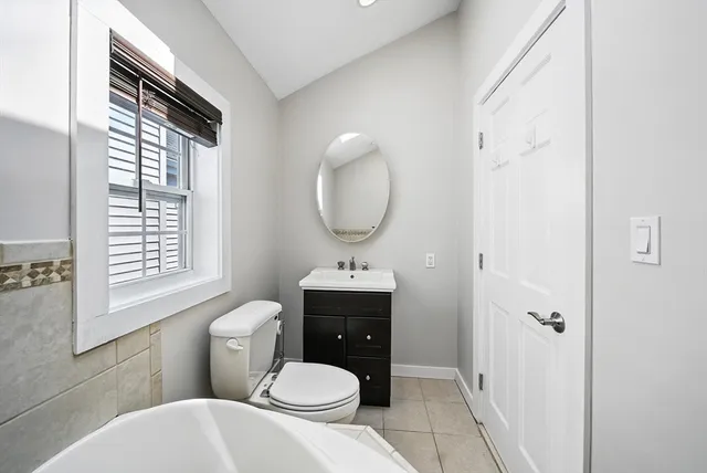 a bathroom with a toilet sink and mirror