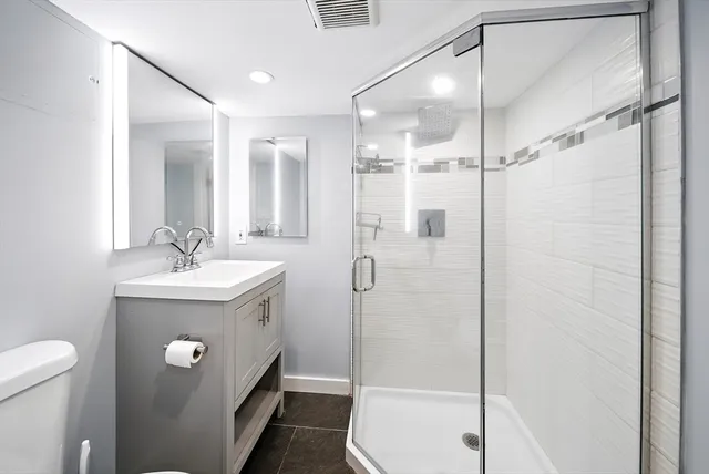 a bathroom with a sink a toilet and shower