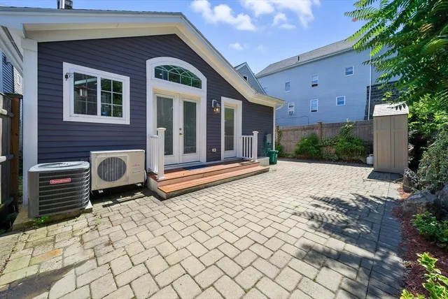 a backyard of a house with barbeque oven table and chairs
