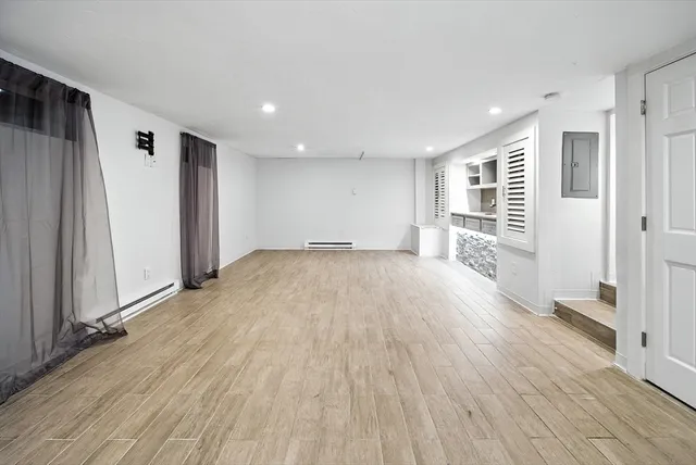 a view of empty room with wooden floor and window