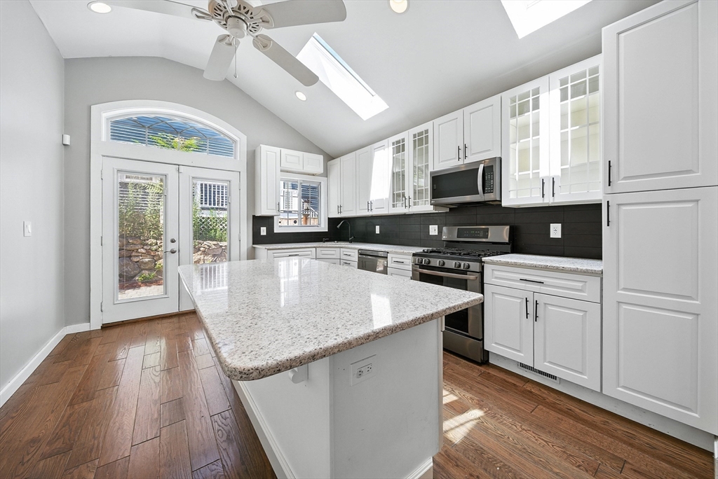 13 Oak Street Salem, MA 01970 - Photo 4 of 42 a kitchen with stainless steel appliances granite countertop a sink a stove top oven a counter space and cabinets