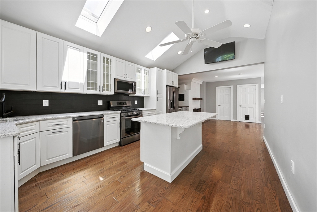 13 Oak Street Salem, MA 01970 - Photo 7 of 42 a kitchen with kitchen island granite countertop a sink cabinets and stainless steel appliances
