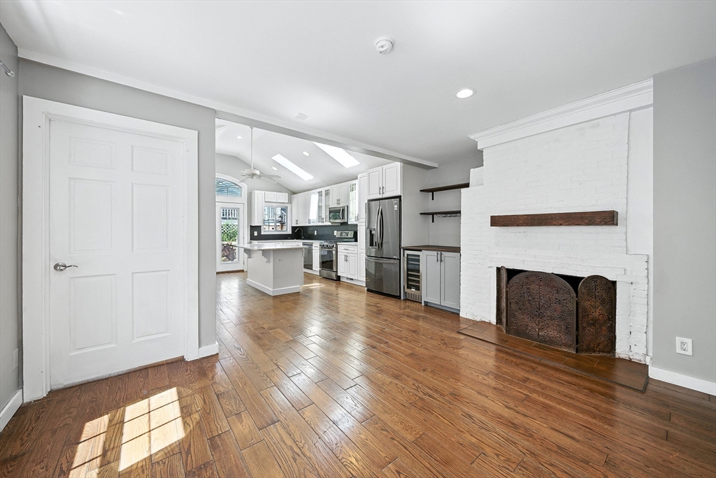 13 Oak Street Salem, MA 01970 - Photo 10 of 42 a view of a kitchen with wooden floor and a fireplace