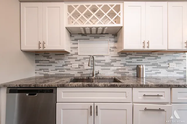 a kitchen with granite countertop white cabinets and a wooden floor