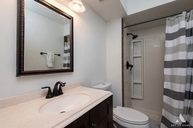 a bathroom with a sink toilet vanity and shower