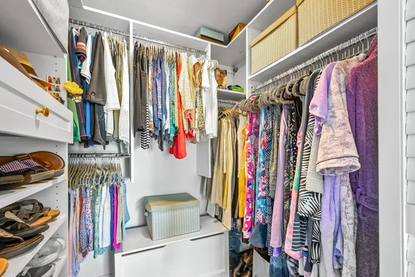 a view of walk in closet with clothes