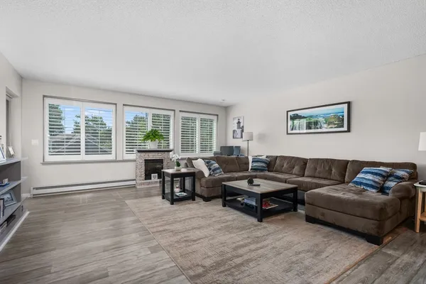 a living room with furniture and two large window with balcony view