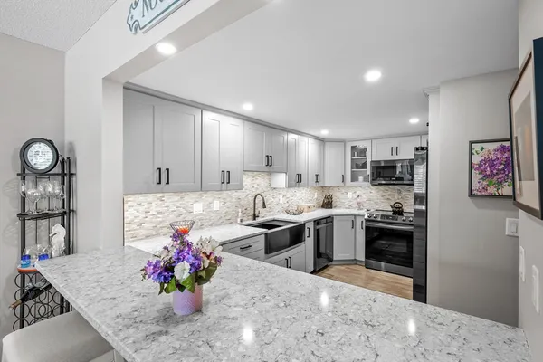 a kitchen with stainless steel appliances kitchen island granite countertop a stove sink and cabinets