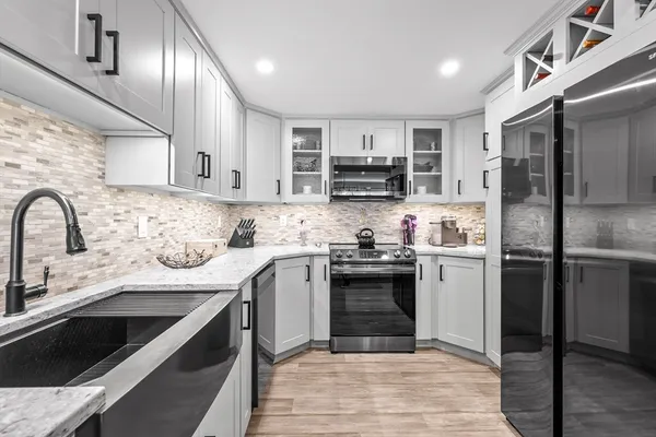 a kitchen with stainless steel appliances granite countertop a sink stove and refrigerator