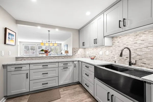 a kitchen with granite countertop white cabinets stainless steel appliances and a sink
