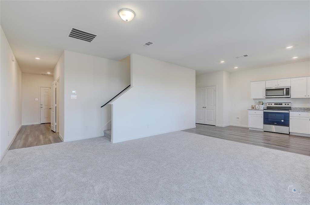 1709 Chapel Hill Road Princeton, TX 75407 - Photo 6 of 25 an empty room with kitchen and fireplace