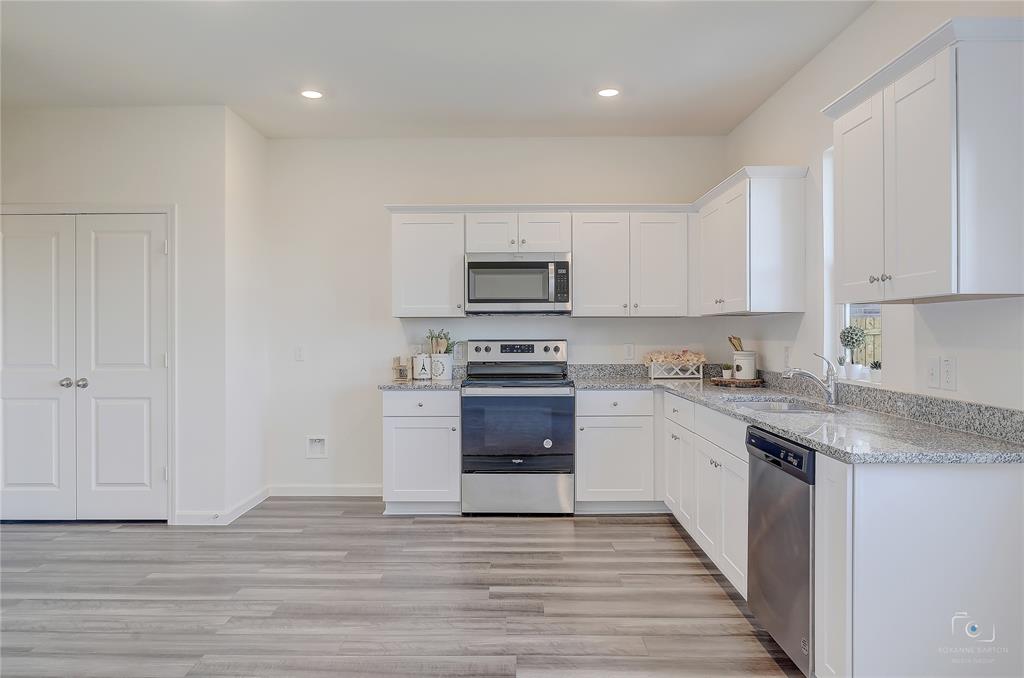 1709 Chapel Hill Road Princeton, TX 75407 - Photo 9 of 25 a kitchen with granite countertop a stove a sink and a microwave