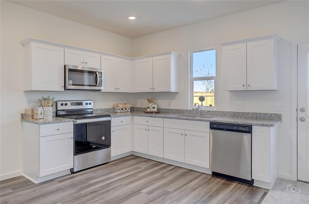 1709 Chapel Hill Road Princeton, TX 75407 - Photo 10 of 25 a kitchen with granite countertop cabinets stainless steel appliances and a wooden floor