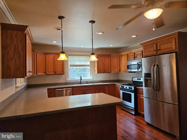 a kitchen with stainless steel appliances granite countertop a sink a stove and a refrigerator