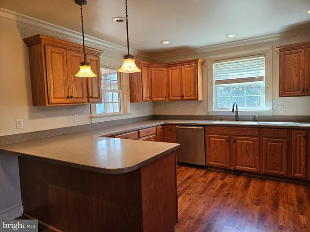 a kitchen with stainless steel appliances granite countertop a refrigerator a sink dishwasher a stove and a refrigerator
