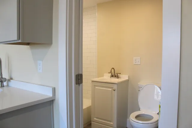 a bathroom with a toilet a sink and mirror