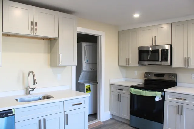 a kitchen with stainless steel appliances a sink a stove a microwave and cabinets