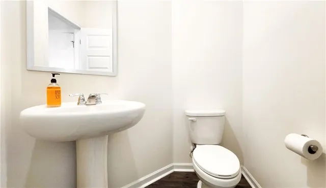a bathroom with a toilet a sink and mirror