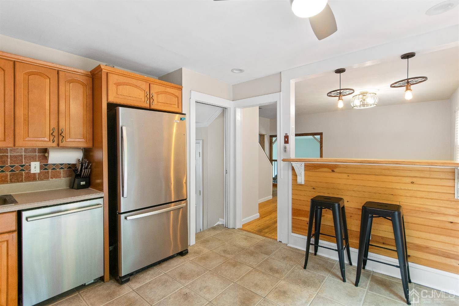 30 Wilk Road Edison, NJ 08837 - Photo 14 of 35 a kitchen with stainless steel appliances granite countertop a refrigerator a stove a sink dishwasher with a dining table and chairs