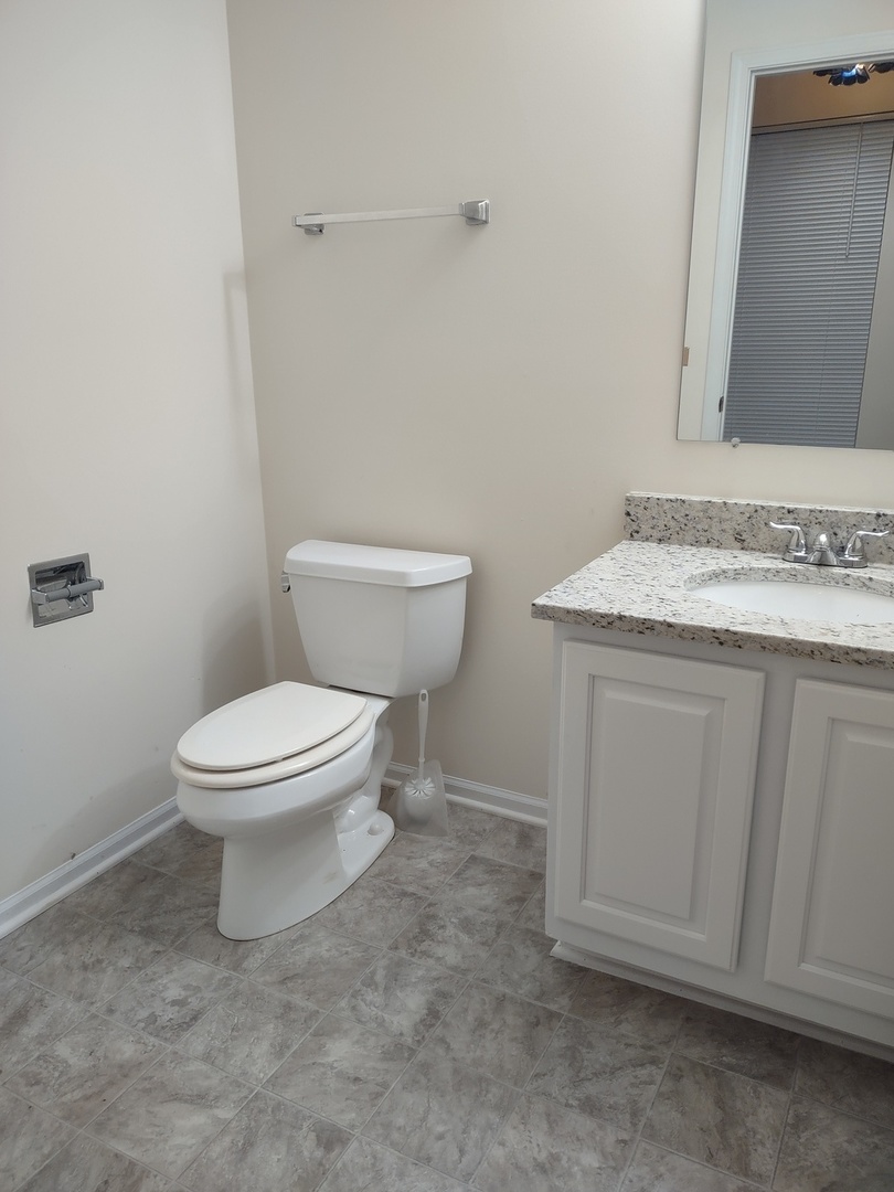 23 Taylor Court, Unit A Streamwood, IL 60107 - Photo 13 of 20 a white toilet sitting next to a bathroom sink