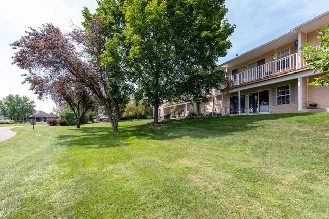 a view of a house with a big yard and palm trees