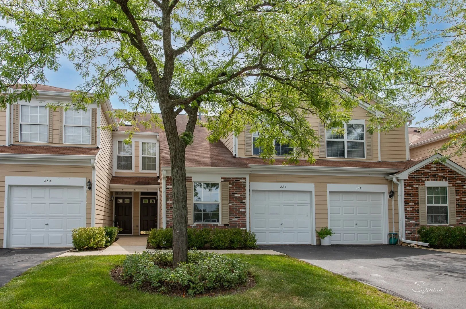 23 Taylor Court, Unit A Streamwood, IL 60107 - Photo 2 of 20 a front view of a house with a yard and garage