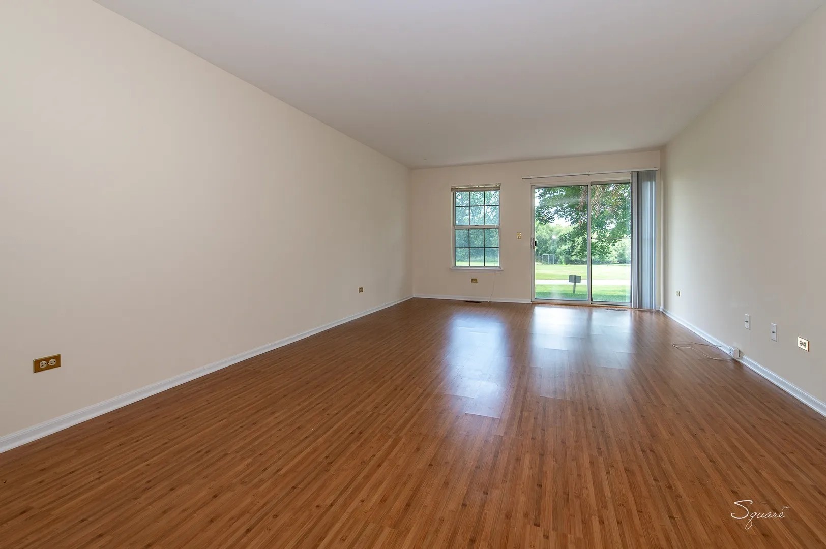 23 Taylor Court, Unit A Streamwood, IL 60107 - Photo 3 of 20 an empty room with wooden floor and windows